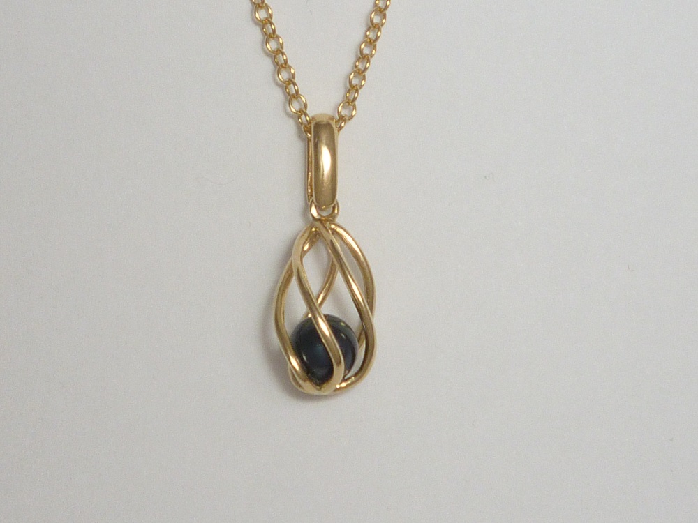 8MM BLACK CULTURED PEARL IN A 9CT YELLOW GOLD TWIST CAGE PENDANT.